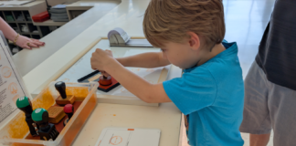 Child stamping a National Parks Passport Book