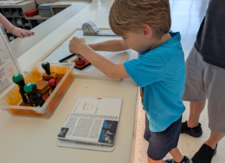 Child stamping a National Parks Passport Book