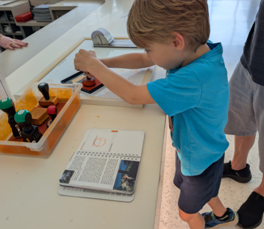Child stamping a National Parks Passport Book